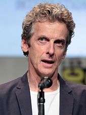 Peter Capaldi seated with microphone