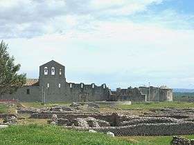 The Parco Archeologico of Venosa, with the walls of the Incompiuta (centre, right) and part of the old church (left, with pink roof); in the foreground, the remains of Roman Venusia