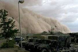 dark brown sand storm about to engulf a motor pool