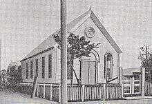 A black-and-white drawing of an old wooden church. The church is small and has no steeple.