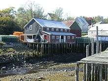 View of several wooden buildings at Seal Cove at low tide