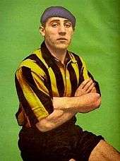 Man in football kit and beret, with his arms crossed