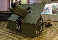 a colour photograph of an artillery piece in a museum building
