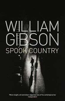 A black-and-white photograph of a man crossing a dimly-lit street. Superimposed in block capitals on the upper half of the photograph is the text WILLIAM GIBSON, and below in smaller text, SPOOK COUNTRY. At the bottom of the image is a quote from the Independent: "More insight, wit and sheer style than any of his contemporaries".
