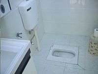 Porcelain squat toilet, with water tank for flushing (Wuhan, China)