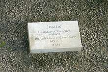 Stone set on the ground which is inscribed with "Justus, first Bishop of Rochester 604–624, fourth Archbishop of Canterbury 624–627, d. 627"