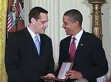 Stuart Milk speaks with Barack Obama, holding the case for the Presidential Medal of Freedom in the White House