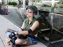 A young woman dressed as Tank Girl sitting down smoking a cigarette