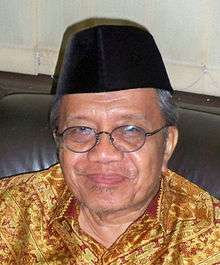 An older Indonesian man in a peci. He is wearing glasses and a batik shirt