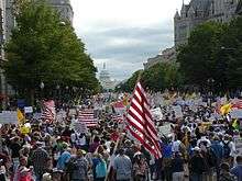 photograph of thousands of people some holding American flags