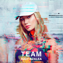 A portrait of a young woman with blonde hair looking straight at the camera, with a white cap. At the bottom center stands the song title, "Team", and the artist name, Iggy Azalea.