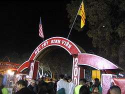 Red-and-white arch, with greeting in Vietnamese