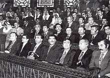 Large group of men sitting in rows