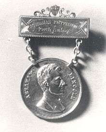 The engraving on the top bar reads "THOMAS PETERSON, Perth Amboy". The hanging medallion is attached to the top bar using two chains. The hanging medallion shows a profile bust of a clean-shaven Abraham Lincoln.