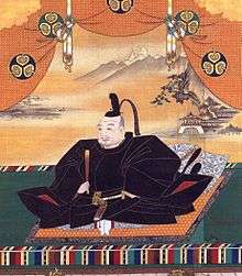 Painting of an mediaeval Asian man seated and dressed in splendour.
