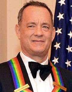 A close up photograph of Tom Hanks smiling while receiving The Kennedy Center Honors Medallion