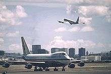 Boeing 747 on the runway and 707 in the air