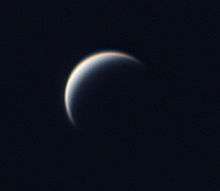 black and white image of Venus, its edges blurred by its atmosphere, a small crescent of its surface illuminated
