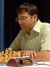 A photograph of a man playing Chess with white set.