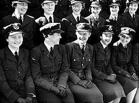 Two rows of seated women in dark military uniforms