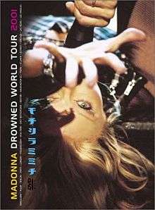 Madonna laying upside down with her hand stretched towards the camera