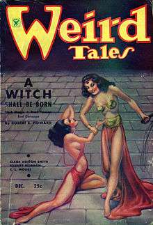Two identical women on a paved floor that fades to shadow in the background. One woman stands, smiling, holding a cat'o'nine-tails whip in her left hand and the other woman's wrist in her right. The second woman kneels helplessly on the floor.