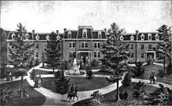 A black and white engraving of the West Virginia Schools for the Deaf and Blind and its campus front lawn